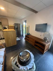a room with a kitchen with a table and a tv at Sab in Beaudreix