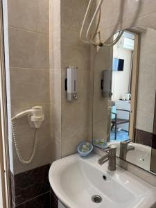a bathroom with a sink and a mirror at Asteria in Odesa +37 photos