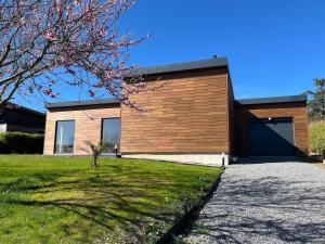 a house with a wooden wall and a garage at maison bois in La Forest-Landerneau