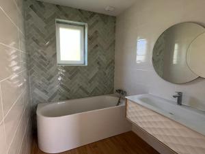a bathroom with a tub and a sink and a mirror at maison bois in La Forest-Landerneau +9 photos