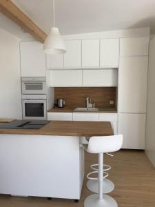 a kitchen with white cabinets and a wooden counter top at maison bois in La Forest-Landerneau