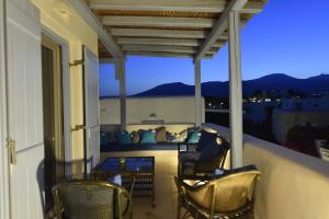 a balcony with chairs and a table with a view at Yria Holiday Home Paros in Márpissa