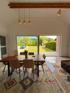 a dining room with a table and a large window at Villa Una Bellevue in Bihać
