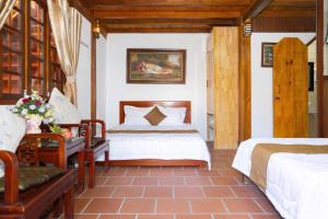 a bedroom with two beds and a chair in it at Bungalows Hill Mũi Né in Ấp Thiện Long