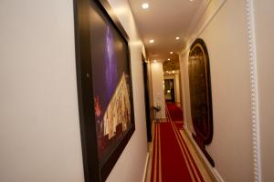 a hallway with paintings on the walls and a red carpet at Royal Plaza Pyramids View in Cairo