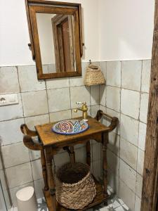 a bathroom with a wooden table with a sink at A casiña do Rieiro in San Pelayo