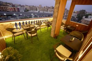 a balcony with tables and chairs and a view of a city at Royal Plaza Pyramids View in Cairo