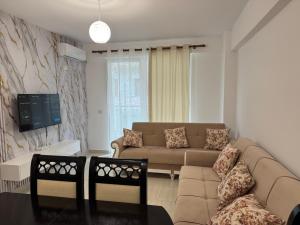 a living room with a couch and a tv at Sea & Mount apartament in Shëngjin