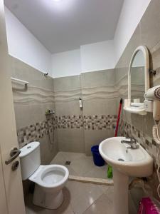a bathroom with a toilet and a sink at Sea & Mount apartament in Shëngjin