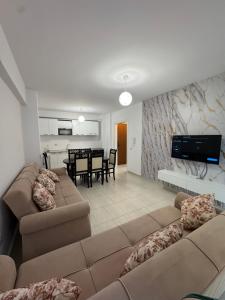 a living room with two couches and a dining room at Sea & Mount apartament in Shëngjin