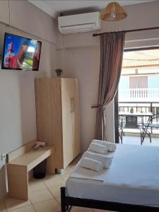a bedroom with a bed and a tv on the wall at House Psichoula in Sarti
