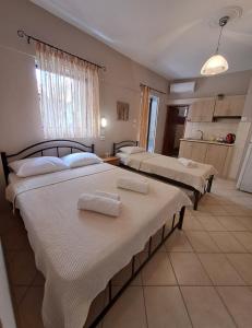 a room with three beds and a kitchen at House Psichoula in Sarti