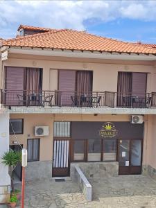 a building with tables and chairs on a balcony at House Psichoula in Sarti