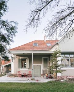 a house with a table and chairs on a patio at Hatablak Boutique Guesthouse in Köveskál in Köveskál