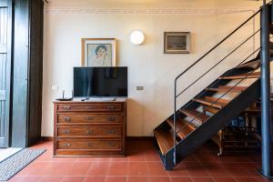 a living room with a television and a staircase at La Cami in Torri del Benaco +5 photos