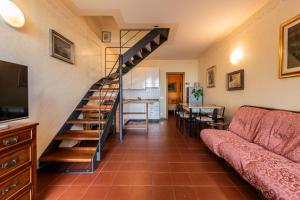 a living room with a staircase and a couch at La Cami in Torri del Benaco