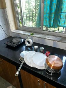 a black counter with plates and a window at Sujata Homestay 2 in Ponda