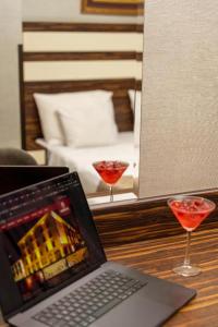 a laptop computer sitting on a table with two wine glasses at Akgun Hotel Beyazit in Istanbul