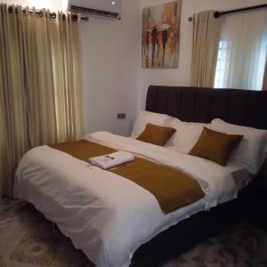 a large bed with a brown and white blanket at Bluetel Hotel and Suites Limited in Sapele