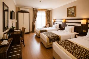 a hotel room with two beds and a desk at Akgun Hotel Beyazit in Istanbul