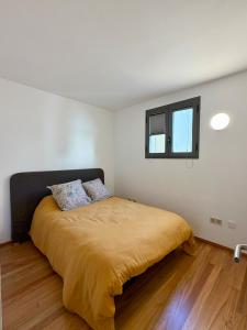 a bedroom with a bed with a yellow blanket at La Força Penthouse in Girona +10 photos