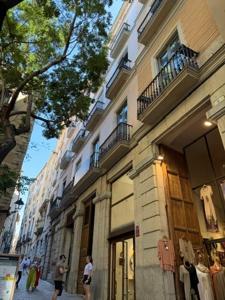 a building on a street with people walking in front of it at La Força Penthouse in Girona