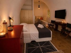 a bedroom with a bed and a table and a couch at Kamara Nest - More than a stay in Aroniadika