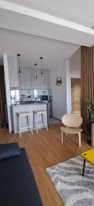 a living room with a table and a kitchen at LuckyCat Apartment in Osijek