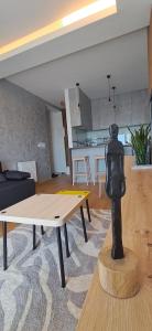 a living room with a statue on a table at LuckyCat Apartment in Osijek +6 photos