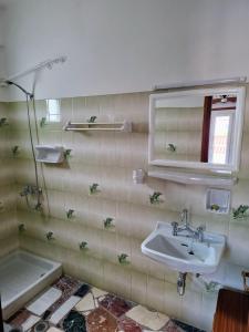 a bathroom with a sink and a tub and a mirror at Lefteris Rooms in Kokkari