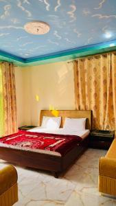 a bedroom with a bed with red sheets and curtains at Mashal Palace in Nathia Gali