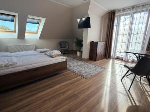 a bedroom with a bed and a table and chairs at Willa Sielanka in Becejły
