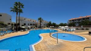 a large swimming pool with chairs and umbrellas at Callao Sun & Pool by Diamanteholidays in Callao Salvaje