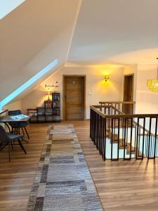 a living room with a staircase and a table and chairs at Willa Sielanka in Becejły