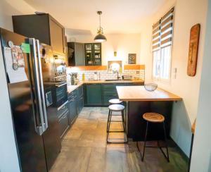 a kitchen with a refrigerator and a counter with stools at Maison de caractère familiale in Béthisy-Saint-Martin +9 photos
