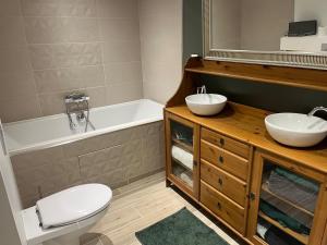 a bathroom with two sinks and a tub and a toilet at Maison de caractère familiale in Béthisy-Saint-Martin