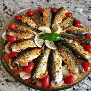 a plate of fish and tomatoes on a table at Chez Malika in Oulad el Guern