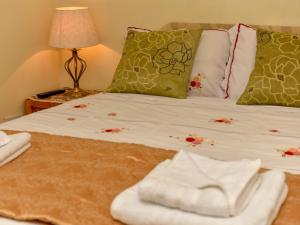 a bed with towels and pillows on it at The Warren Guest House in Carlisle