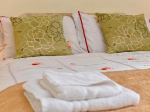 a bed with a pile of white towels on it at The Warren Guest House in Carlisle