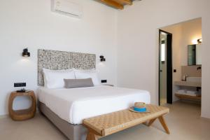 a bedroom with a large white bed and a table at Refoulia Eco Suites in Vathi +107 photos