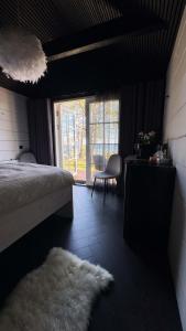 a bedroom with a bed and a chair and a window at Ülesaare kämping in Kelnase