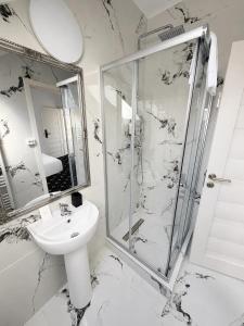 a white bathroom with a shower and a sink at Rosetti Inn in Cluj-Napoca