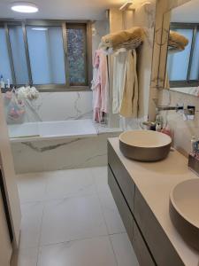 a bathroom with two sinks and a bath tub at Garden villa Raanana in Ra‘ananna +20 photos