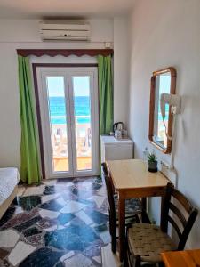 a room with a table and a view of the ocean at Lefteris Rooms in Kokkari