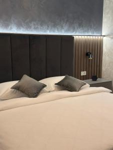 a large bed with two pillows in a bedroom at Apartman KATY - self check-in, besplatan parking, blizu centra in Vukovar