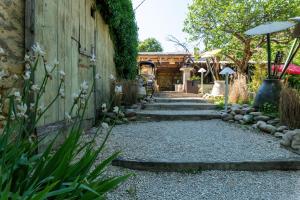 a garden with a stone walkway next to a building at Hôtel O Mamma Mia in Lourmarin