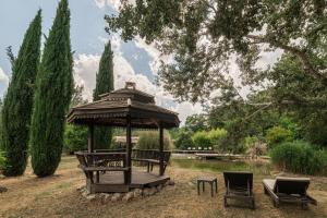 a gazebo with a table and chairs in a park at Hôtel O Mamma Mia in Lourmarin
