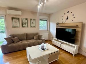 a living room with a couch and a flat screen tv at Apartman Mara in Solin