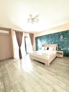 a bedroom with a bed and a painting on the wall at Apartamente & Studiouri Melia Eforie Nord in Eforie Nord