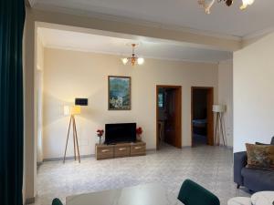 a living room with a television and a couch at Vogli's House Apartments & Rooms in Durrës